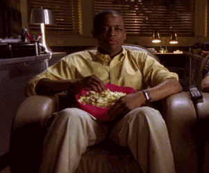 GIF of man enjoying popcorn in front of a screen