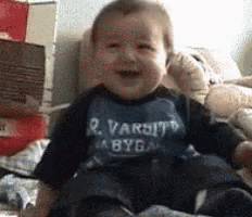 GIF of baby laughing and falling over
